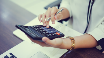 Mulher fazendo cálculos em uma calculadora