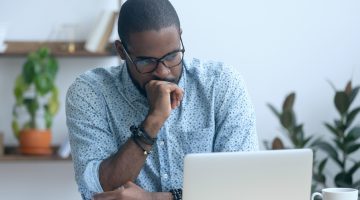 Homem negro analisando a tela do computador