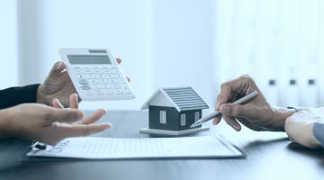 mãos com calculadoras e canetas fazendo menção à base de cálculo do ITBI