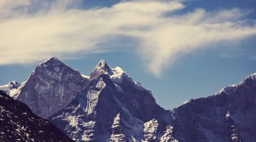 Montanhas de neve e céu azul com nuvens