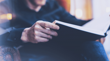 homem segurando um livro com as novidades do mundo tributário em 2022